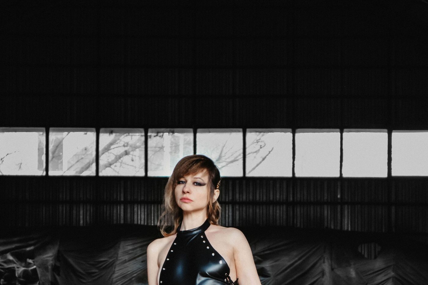 Femme en cuir noir dans un espace industriel