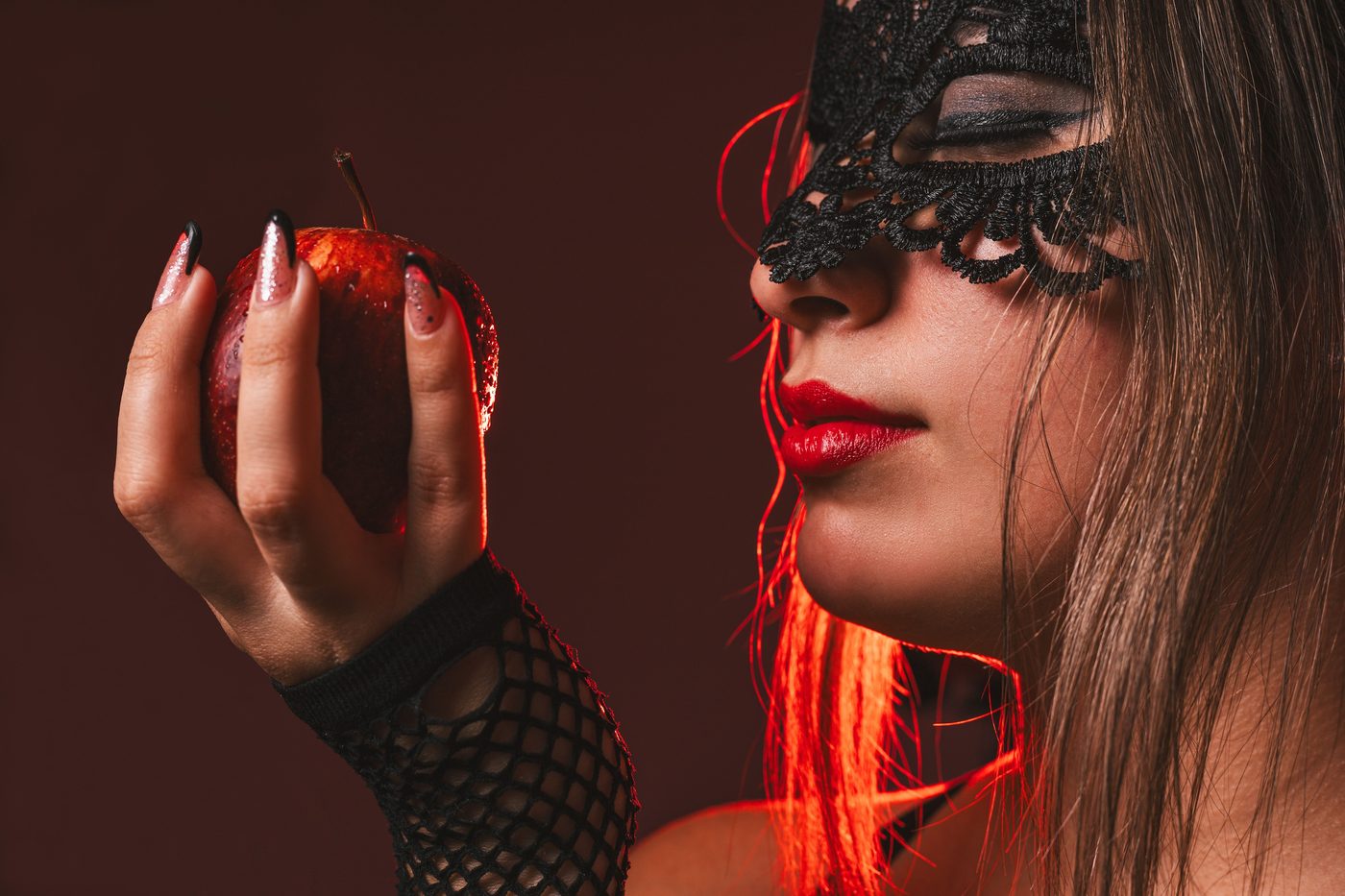 Femme avec masque de dentelle noire et gants résille